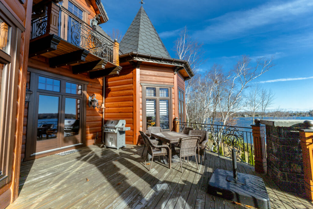 A wood deck off an orange-red cottage