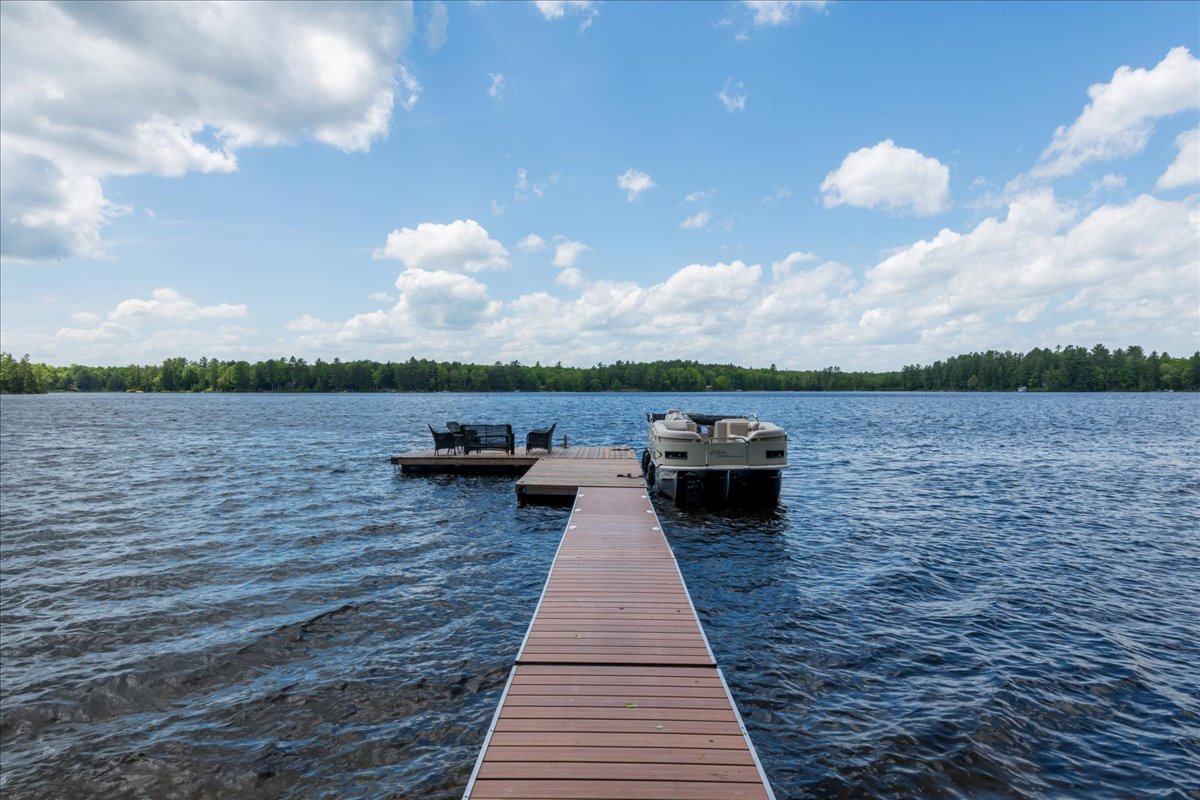 A dock in the lake with a boat at the end