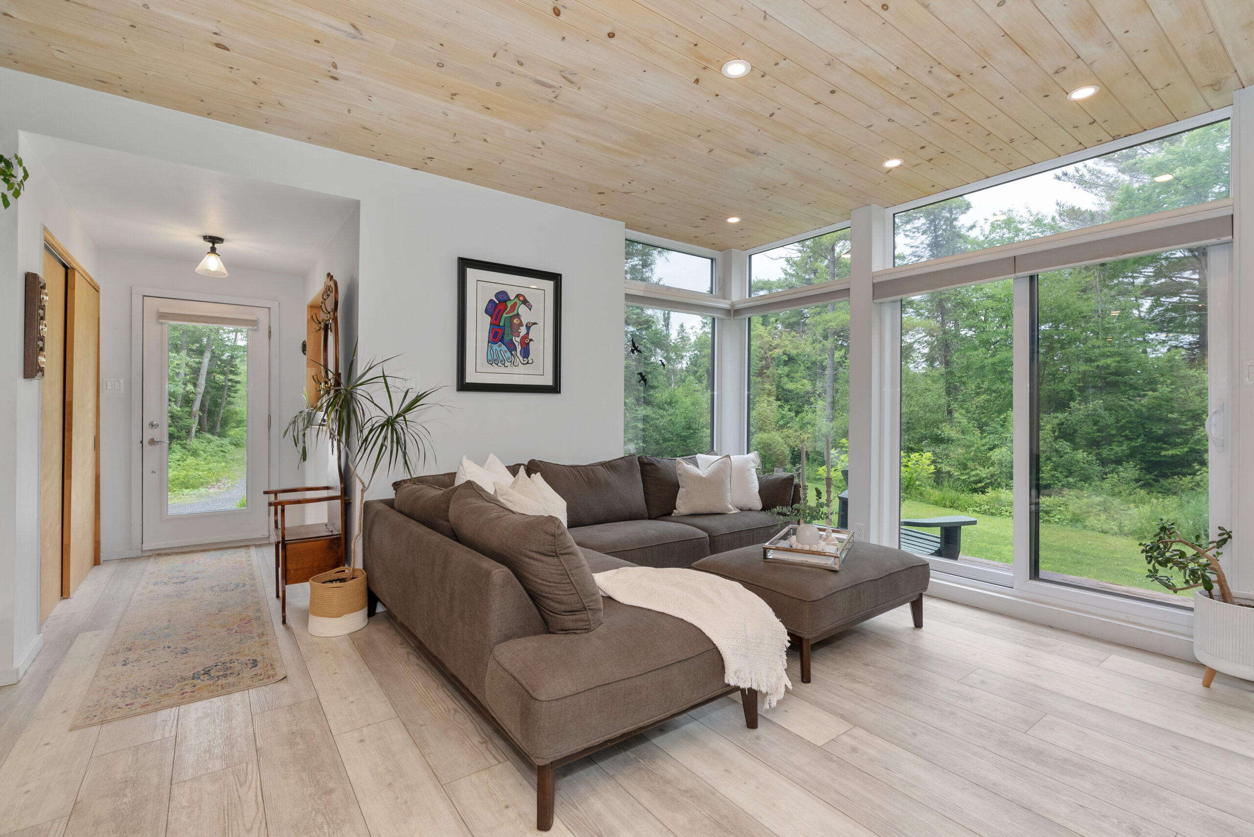 An L-shaped grey couch in a bright room with huge glass windows