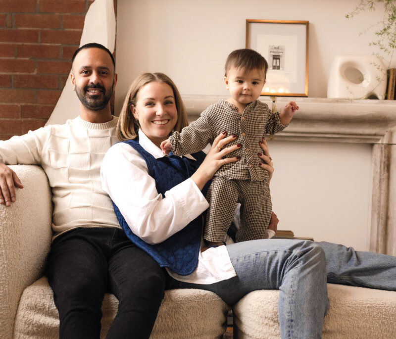 a young family smiles for a photo