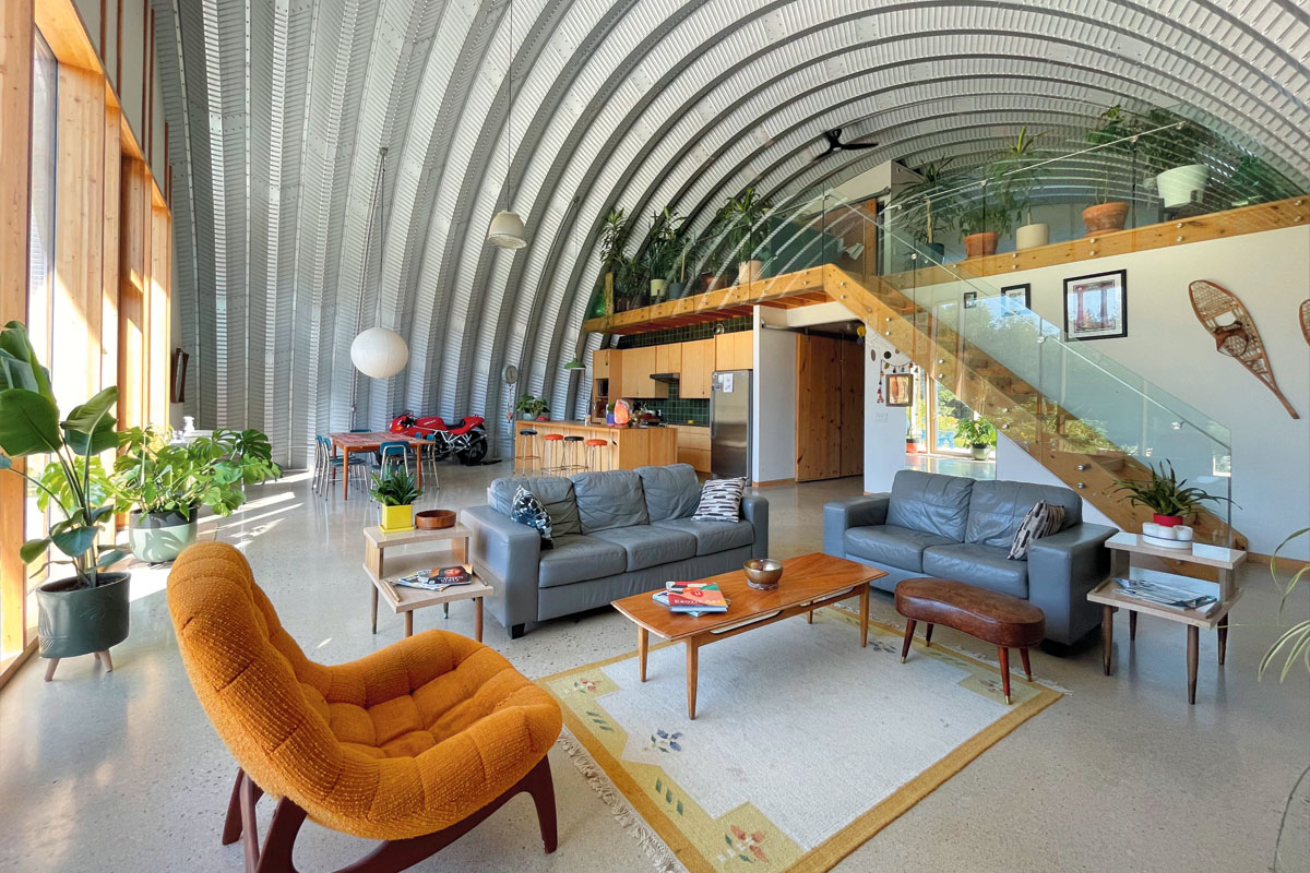 a living room with a rust-coloured chair and blue couches