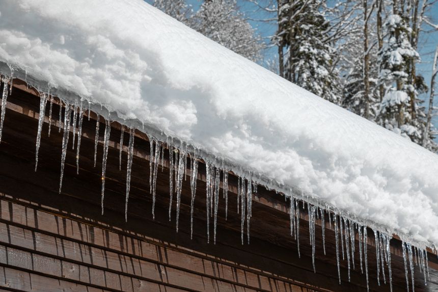 A roof covered with snow and icicles