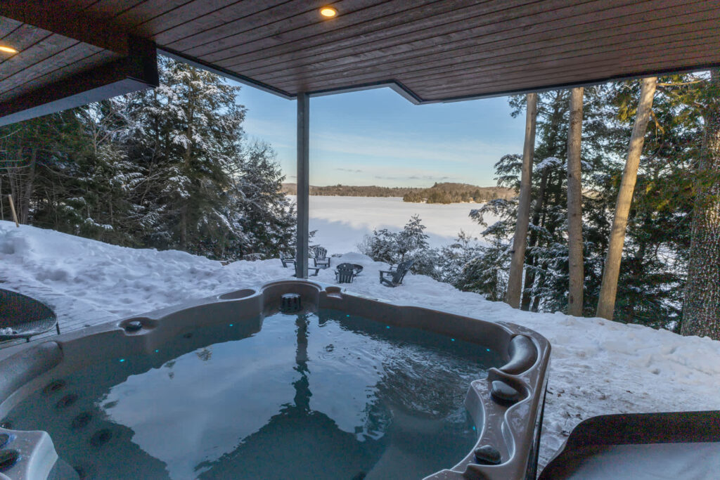 A hot tub that looks over a snowy hillside