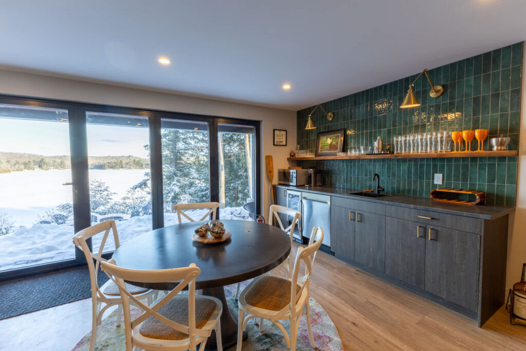A small round dining table next to a built-in green tiled bar