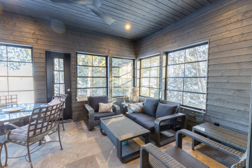 Grey couches in a dark-painted sunroom