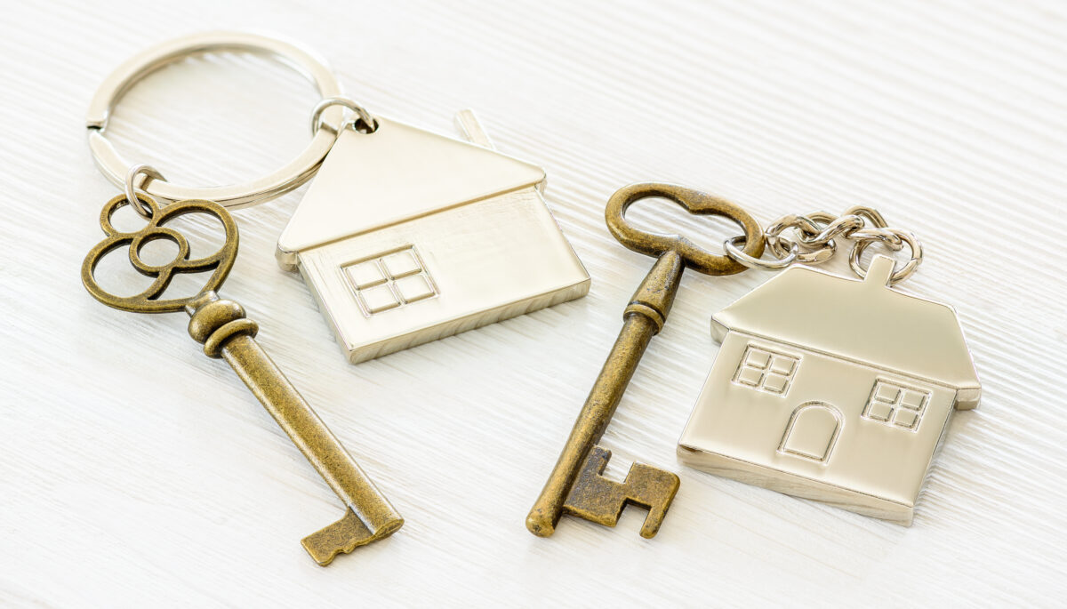 two metal keychains with houses on them