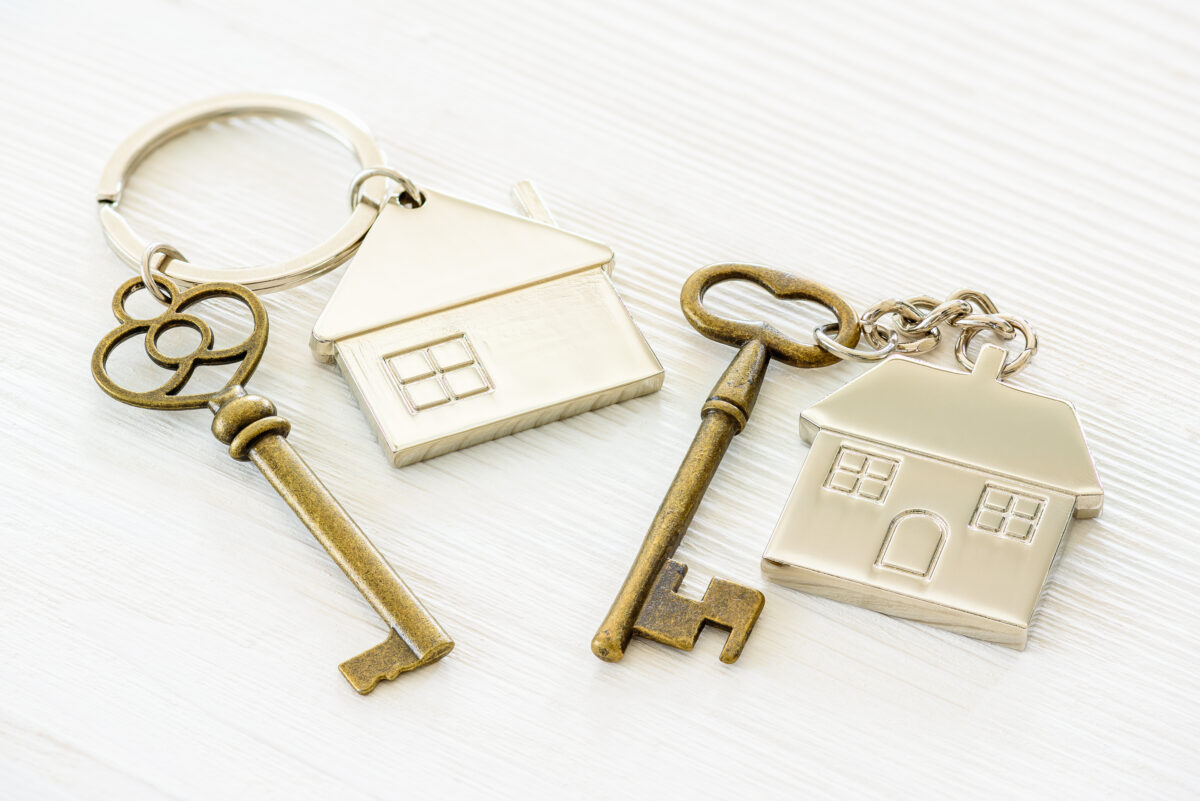 two metal keychains with houses on them