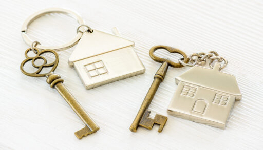 two metal keychains with houses on them