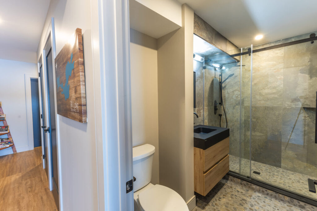 A toilet next to a glass shower