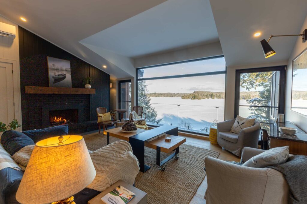 A huge window overlooks a snowy lake