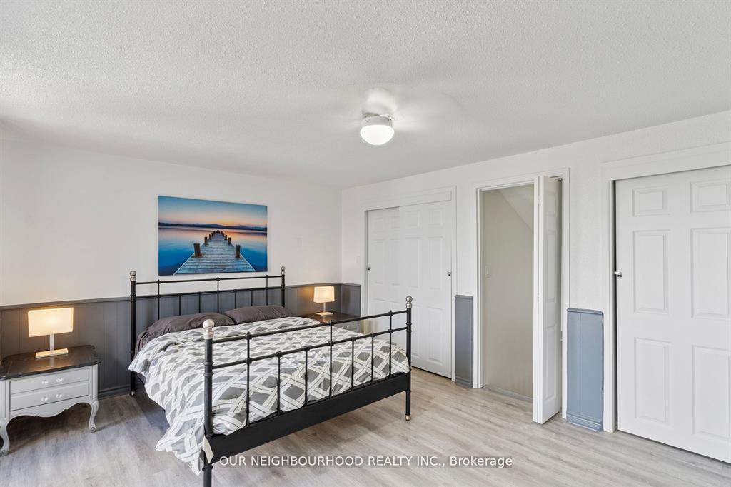 A white bed on a black bed frame in a white room