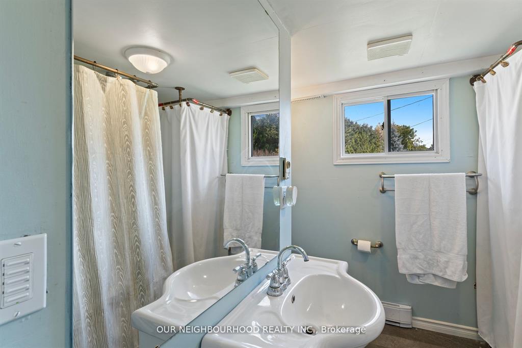 A light blue bathroom with a white sink and white shower curtains