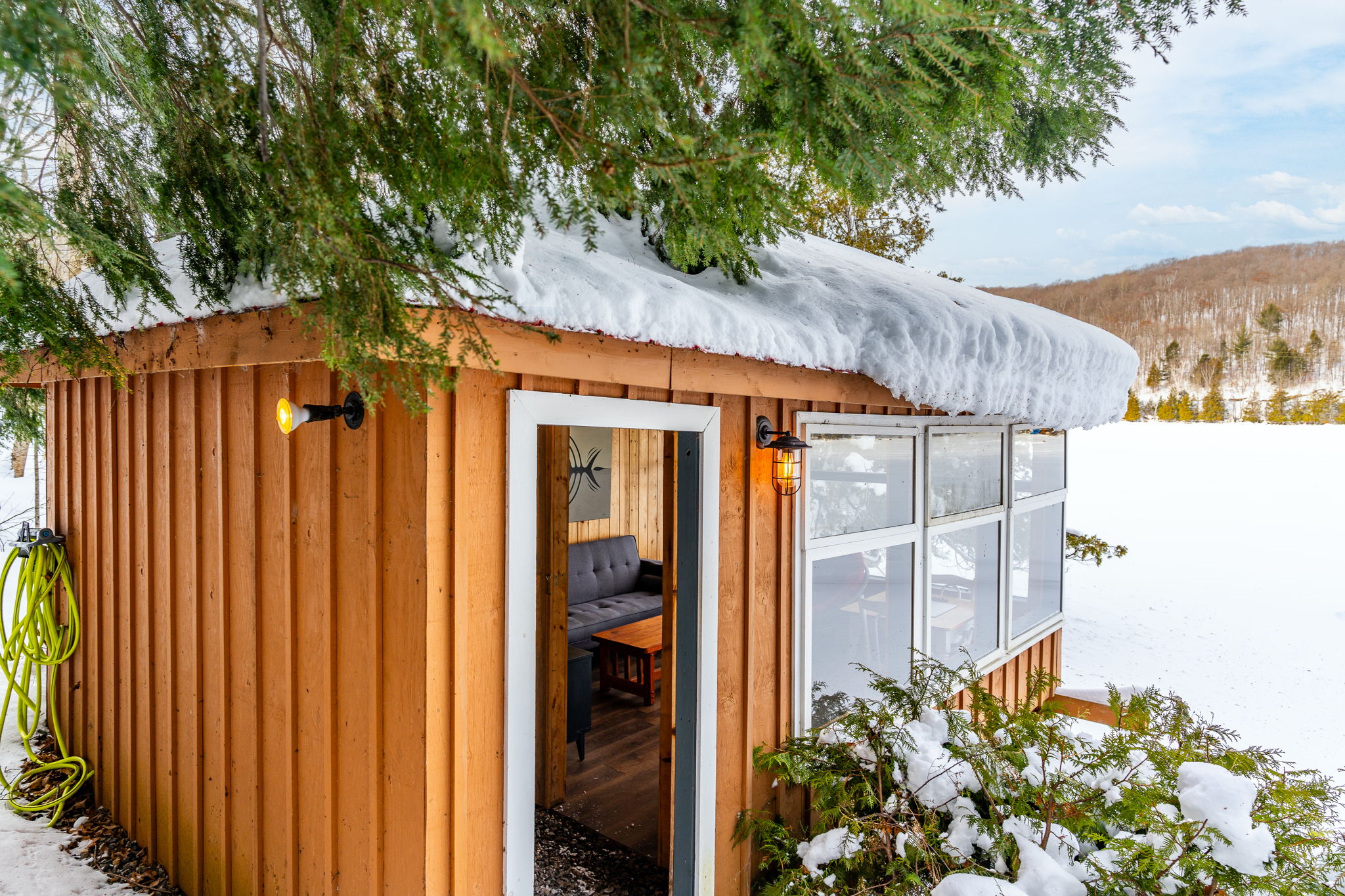An open doorway leads into the wood bunkie