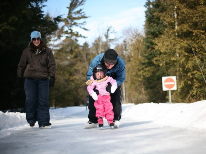 Two adults and a toddler on an ice skating trail