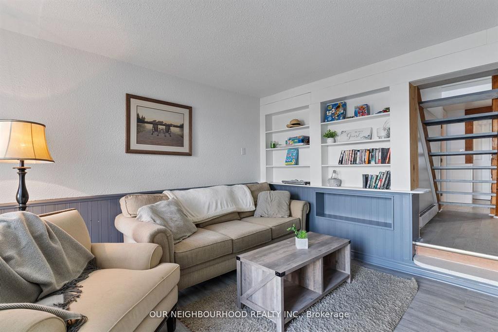 A beige couch next to a white and blue built-in bookshelf