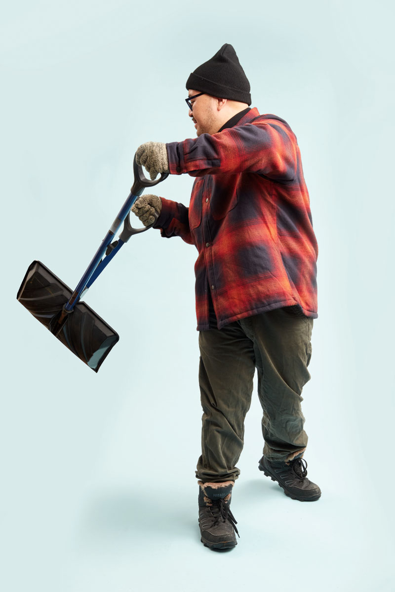 a photo of a person in a plaid jacket holding a shovel