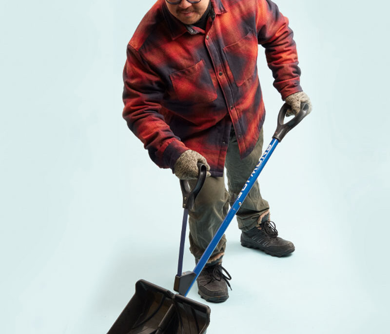 a photo of a person in a plaid jacket holding a shovel