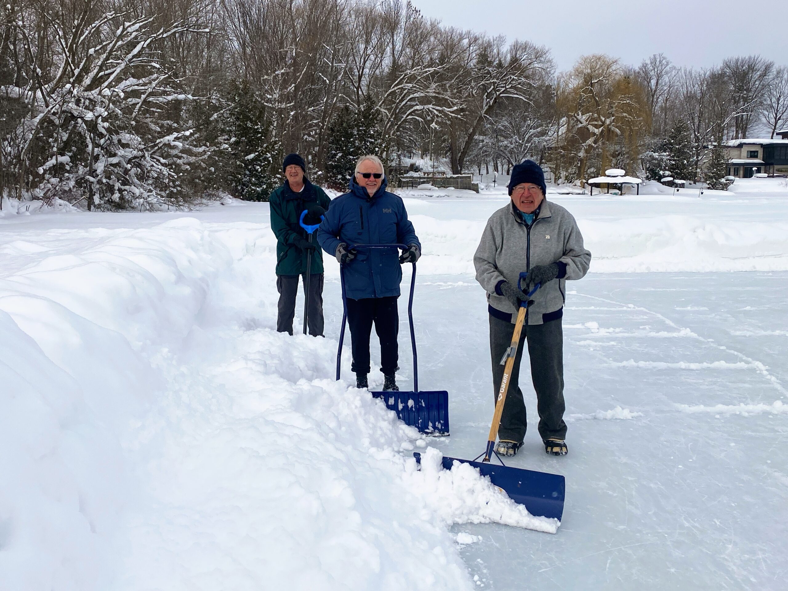 The three volunteers clearing snow off the ice