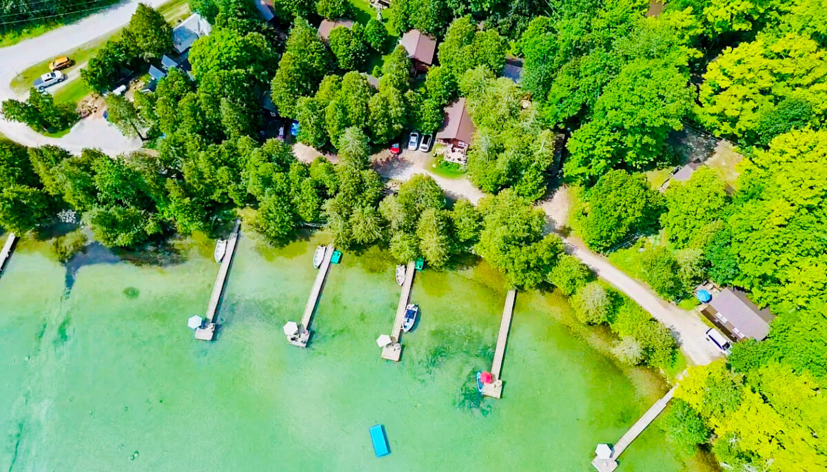 A stunning aerial perspective showing the resort’s sandy shoreline and multiple cabin locations.