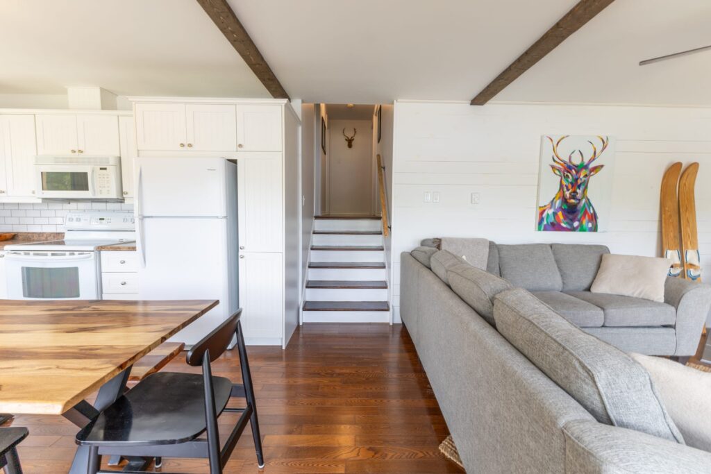 a set of steps divide a wood dining table and grey couch