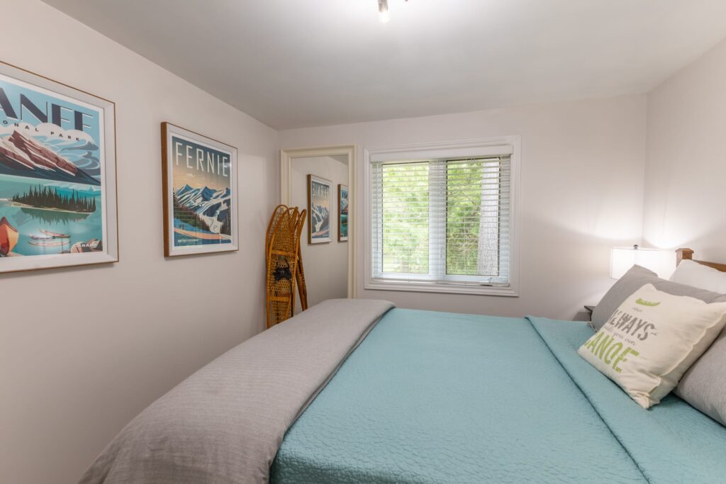 A bed with a turquoise cover and a white blanket at the end