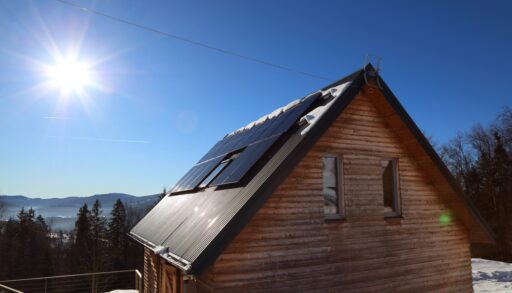 A cabin with solar panels against a winter background