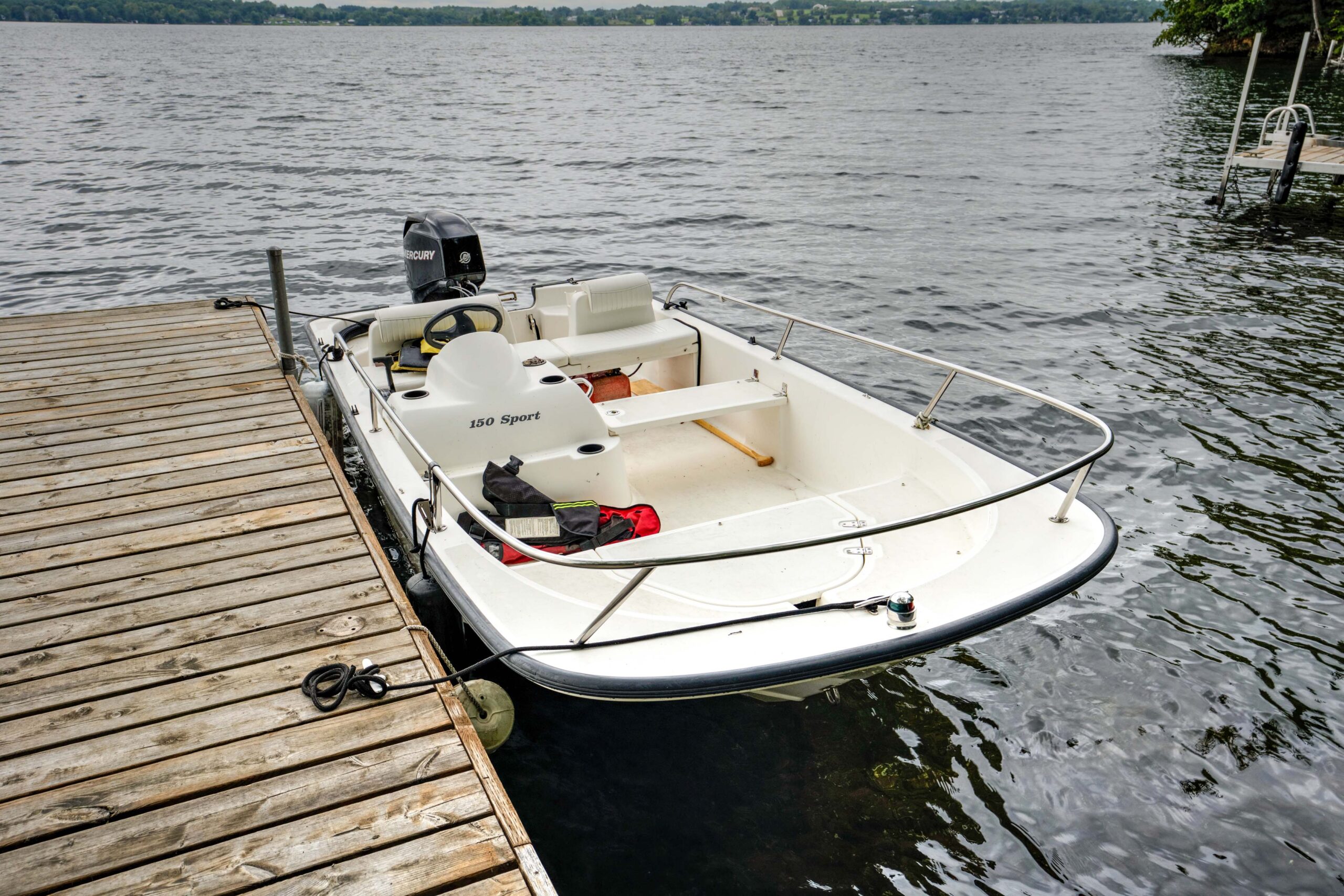 A white boat tied to a dock.