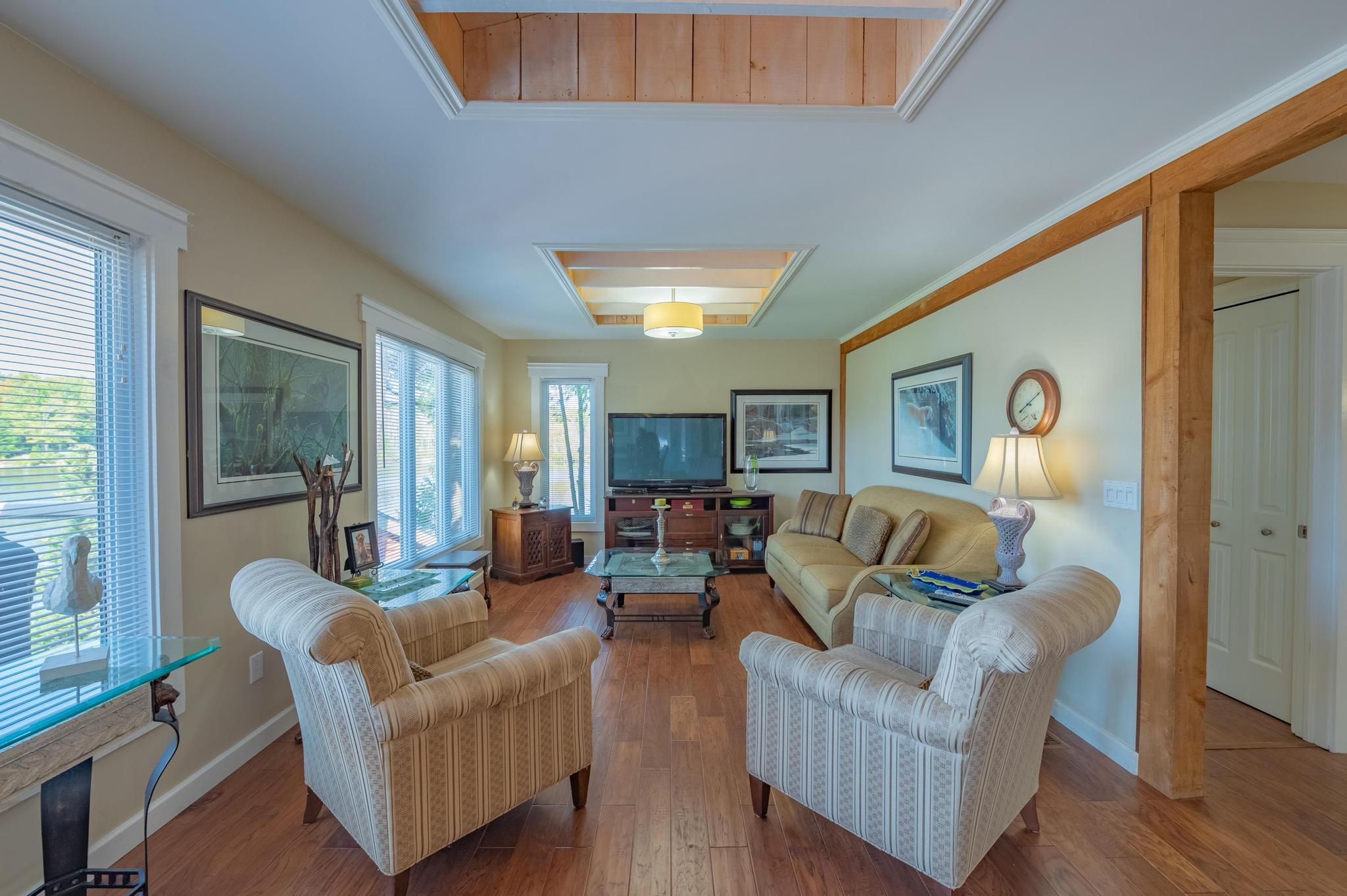 A bright and airy cottage living space with stylish furnishings and large windows.