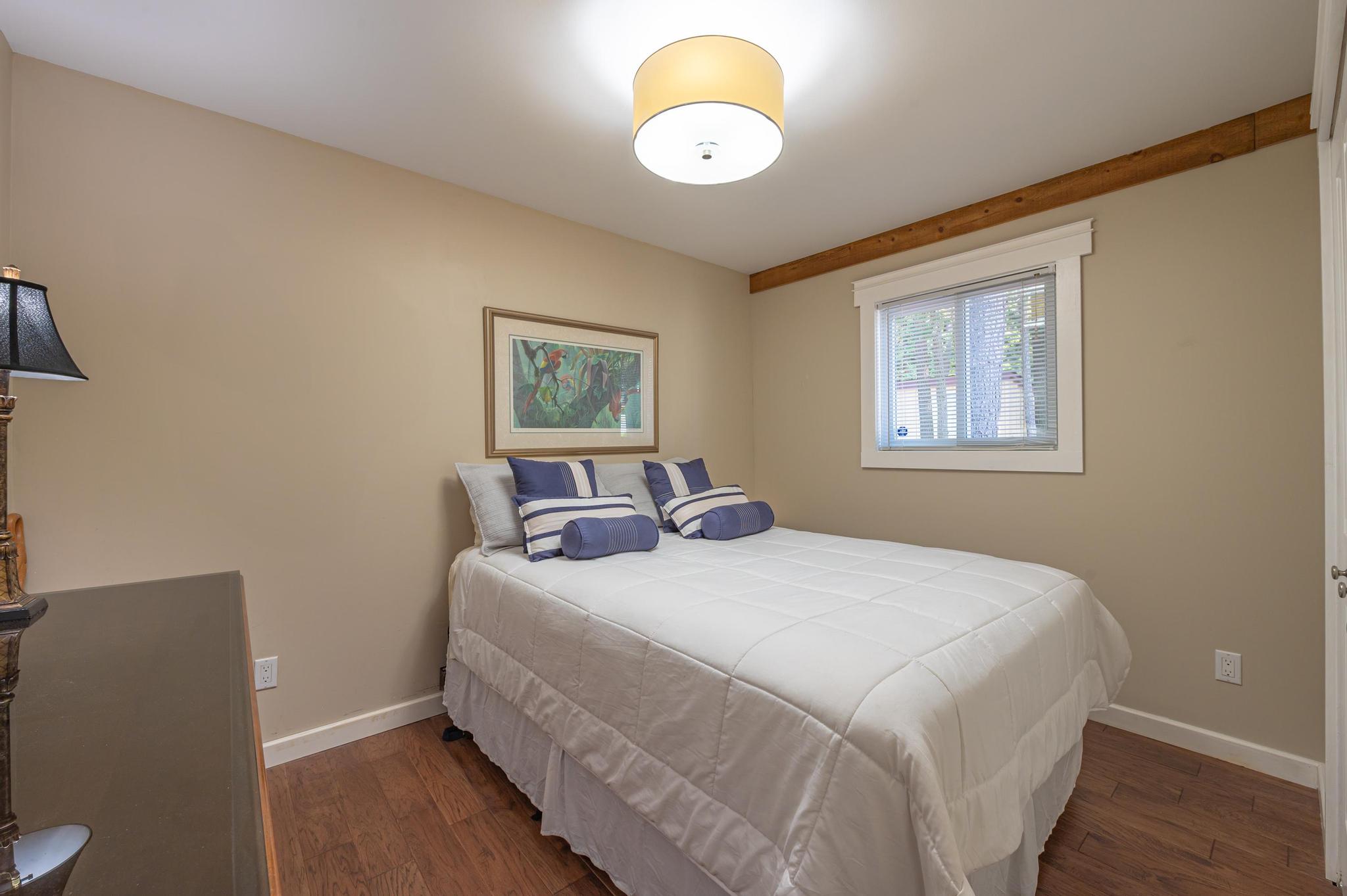 A comfortable bedroom with soft lighting and a neatly made bed.