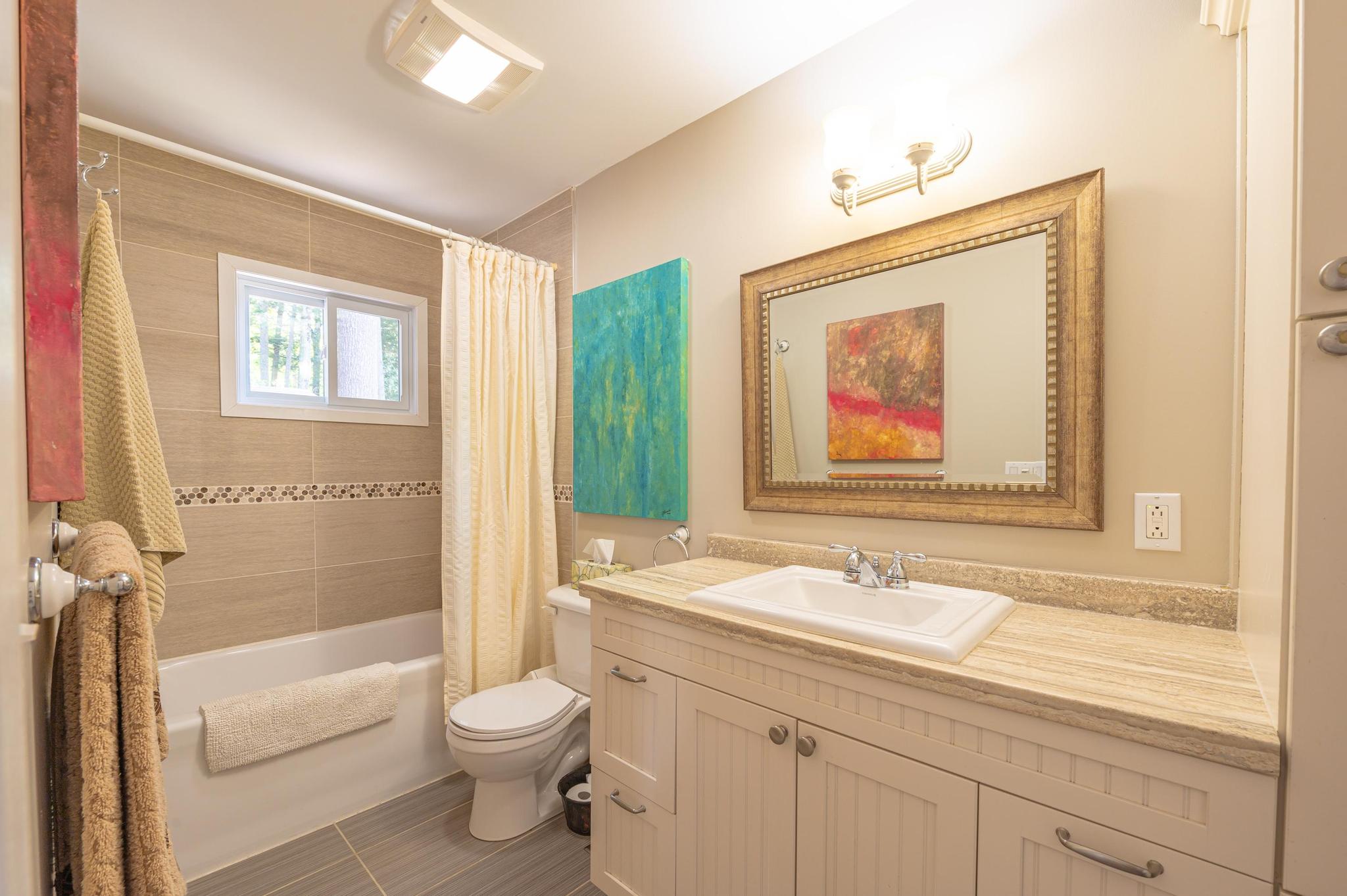 A bathroom with modern fixtures, a large mirror, and a walk-in shower.