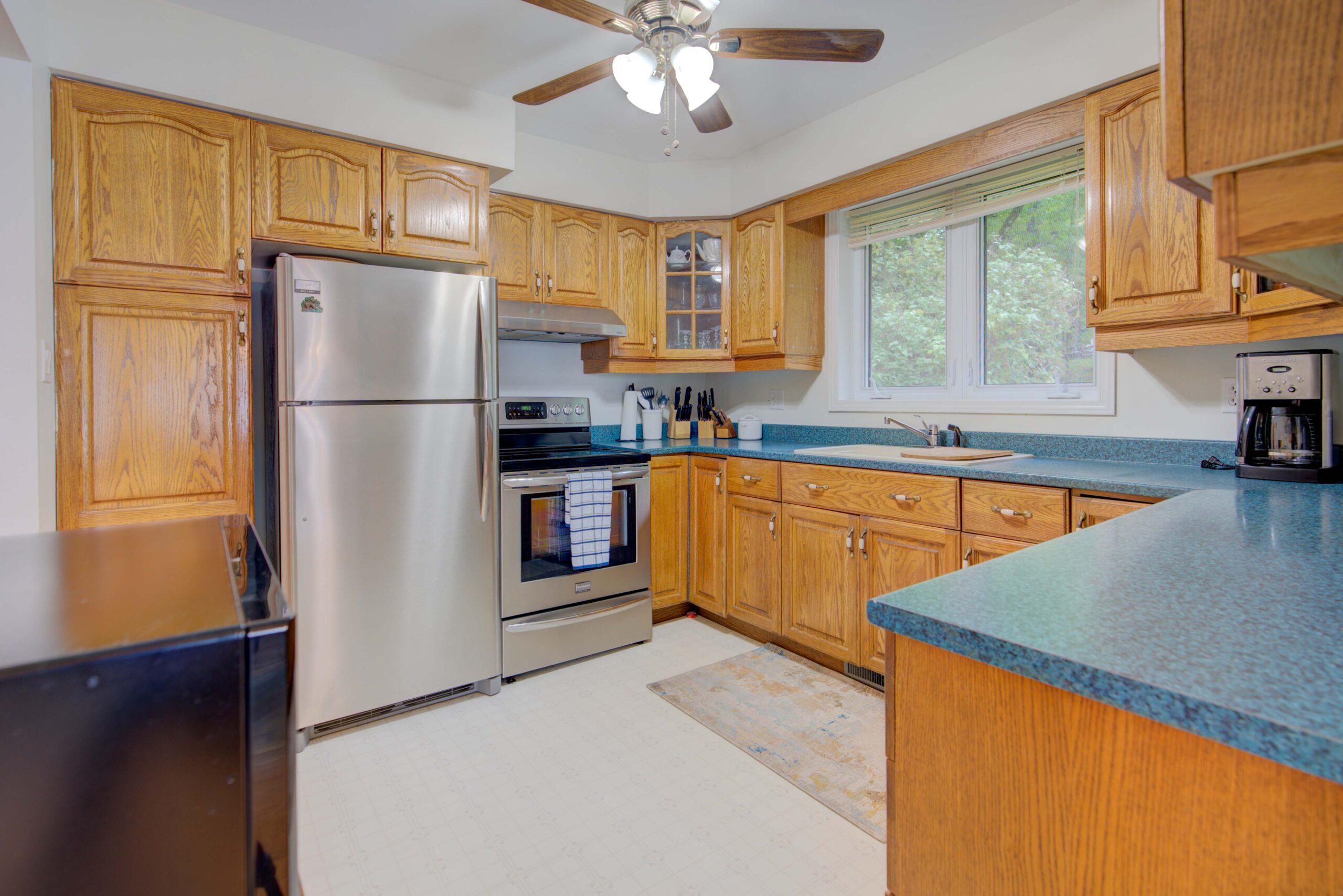 A small kitchen with wood cabinets and a