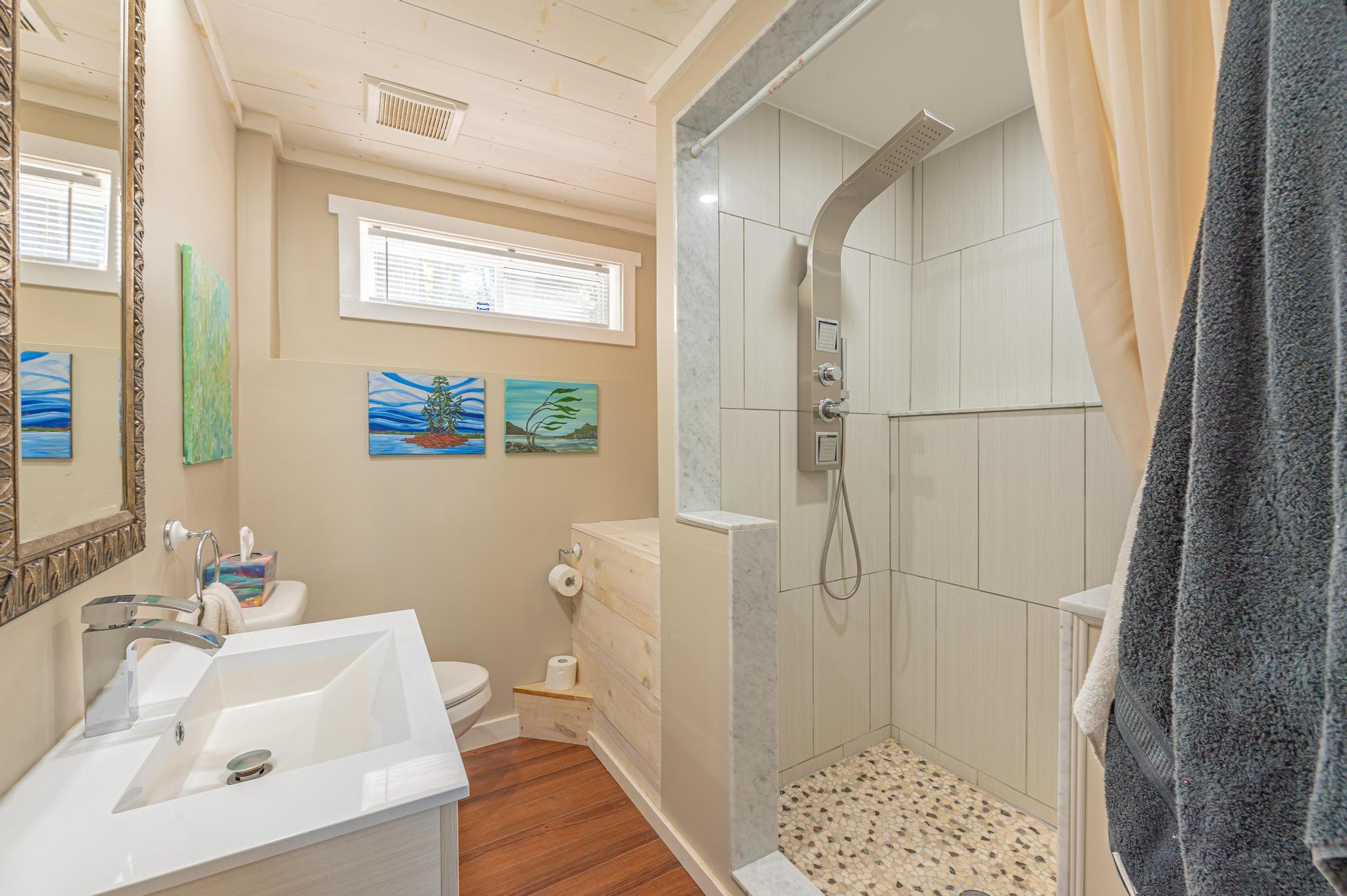 A full bathroom with an elegant design, featuring a vanity and walk-in shower.
