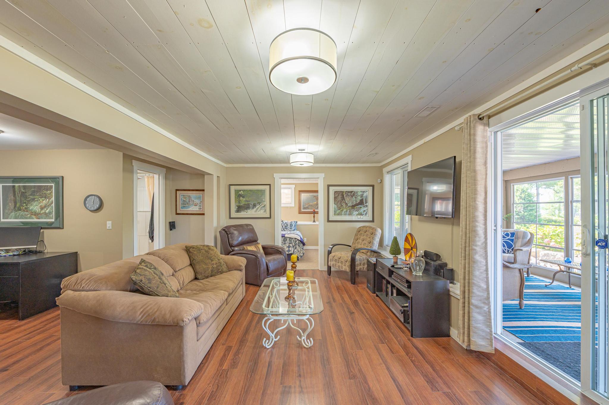 A cozy dining room with a wooden table and large windows offering views of the lake.