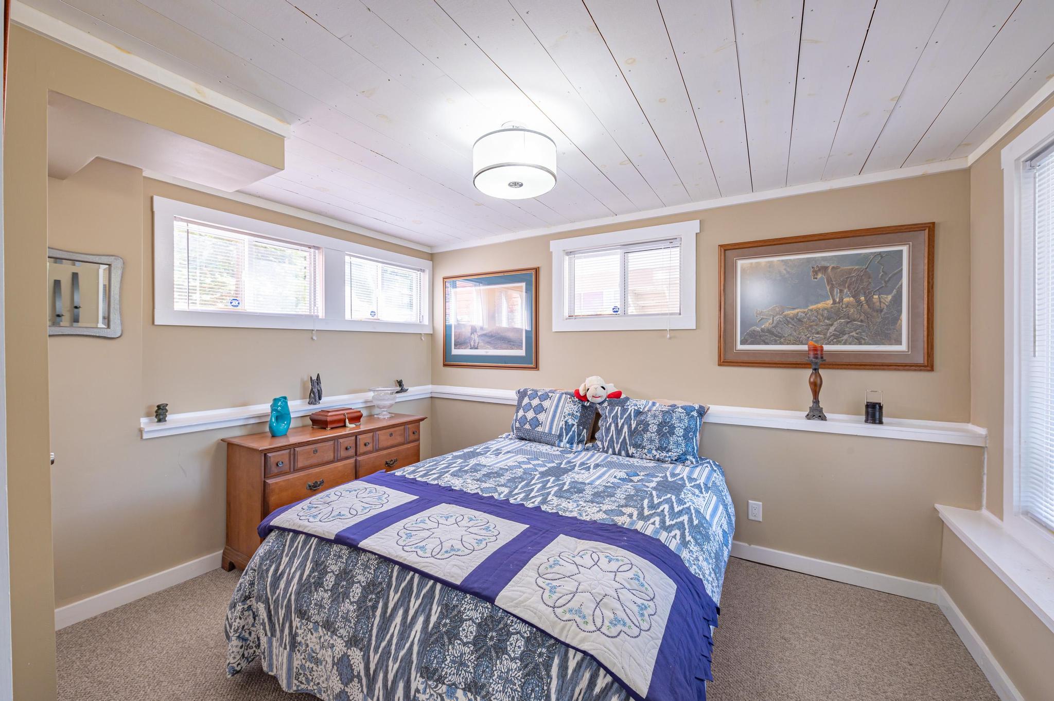 A beautiful lakeside bedroom featuring white linens and cozy decor.