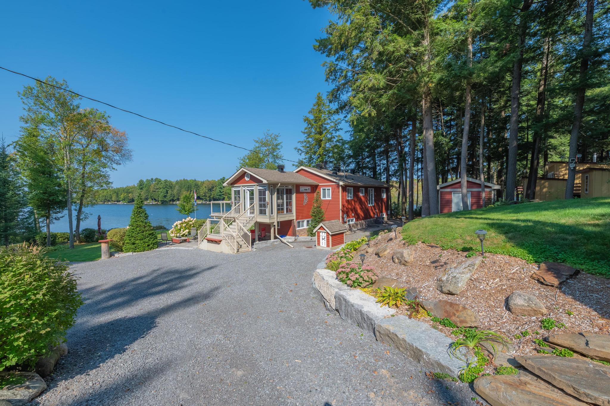 A beautiful lakeside view from the driveway, showcasing a well-maintained path leading to the water.