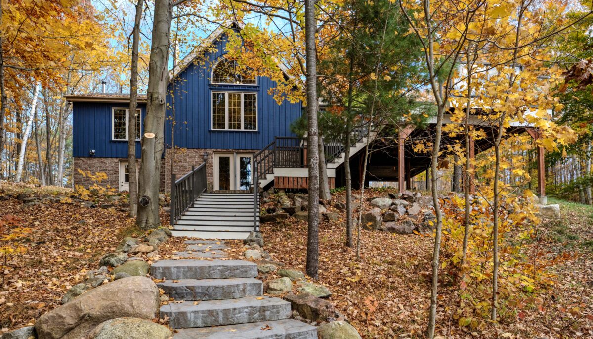 A blue cottage with stone steps in an autumn forest