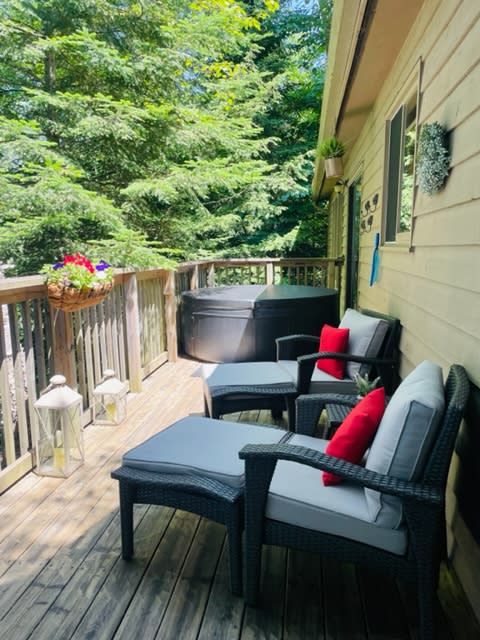 Black lounge chairs with blue cushions face out from the deck. At the end, a covered hot tub