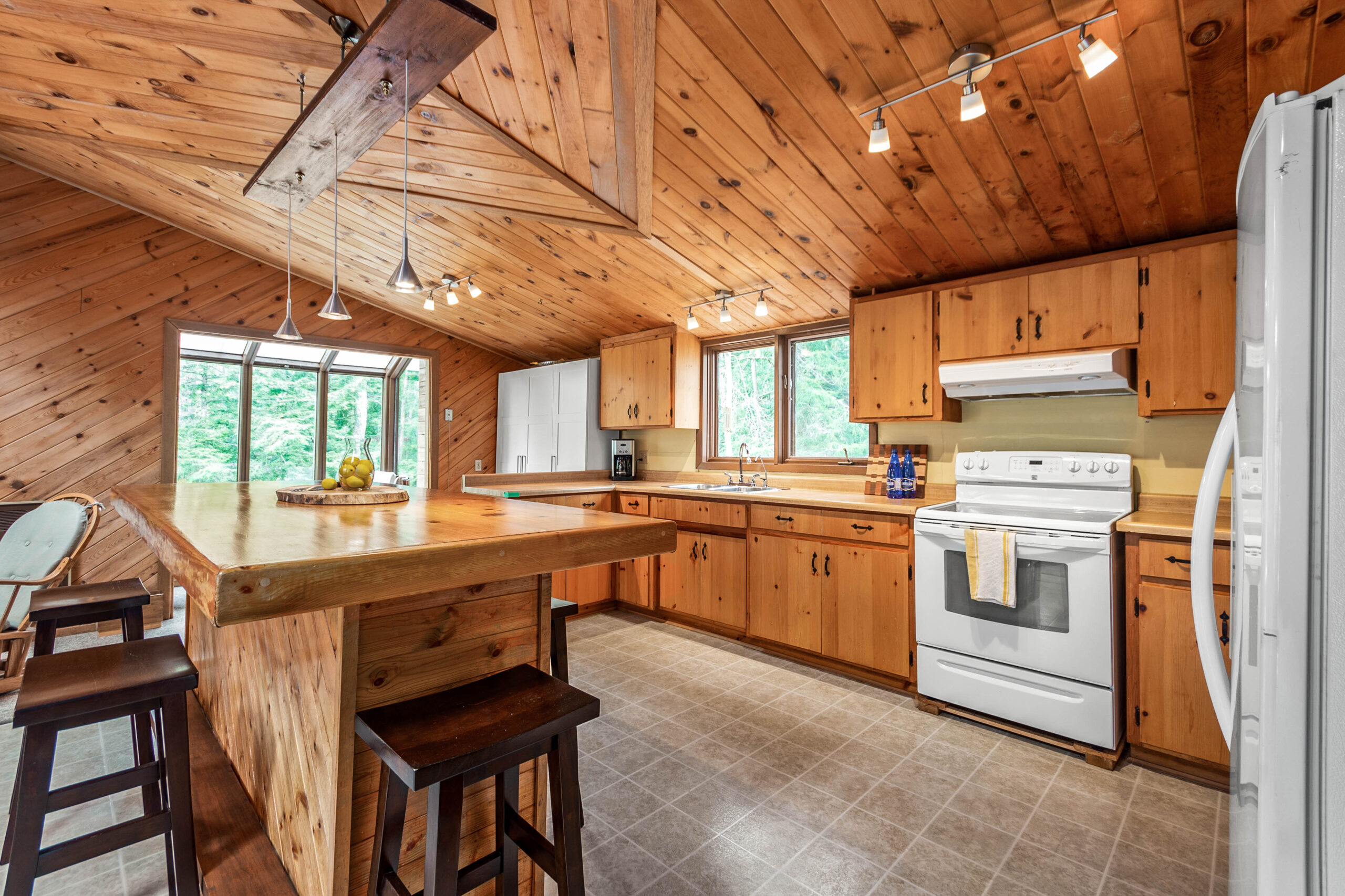 A wood-paneled kitchen with wood cabinets and a wood kitchen island
