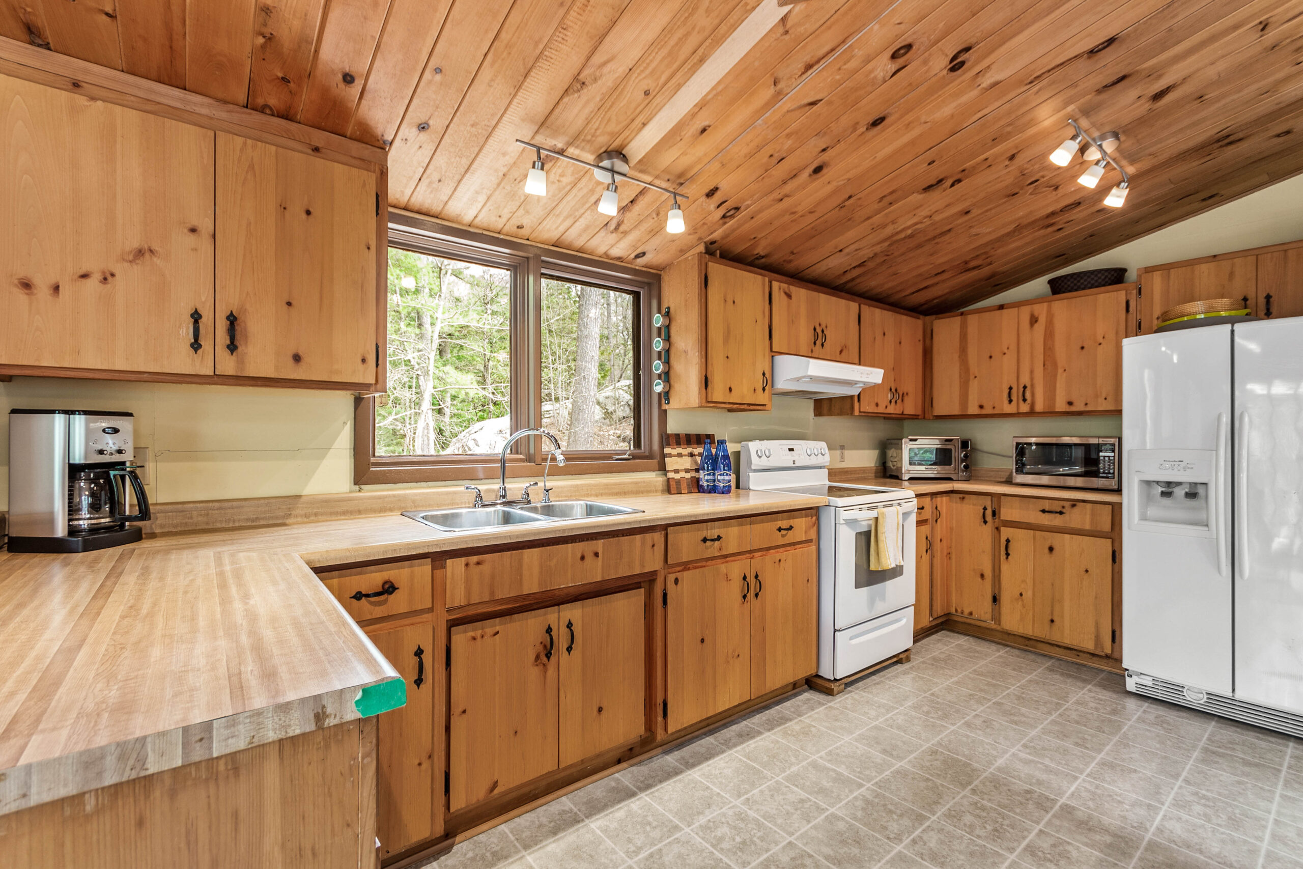 A wood-paneled kitchen with wood cabinets and a white stove
