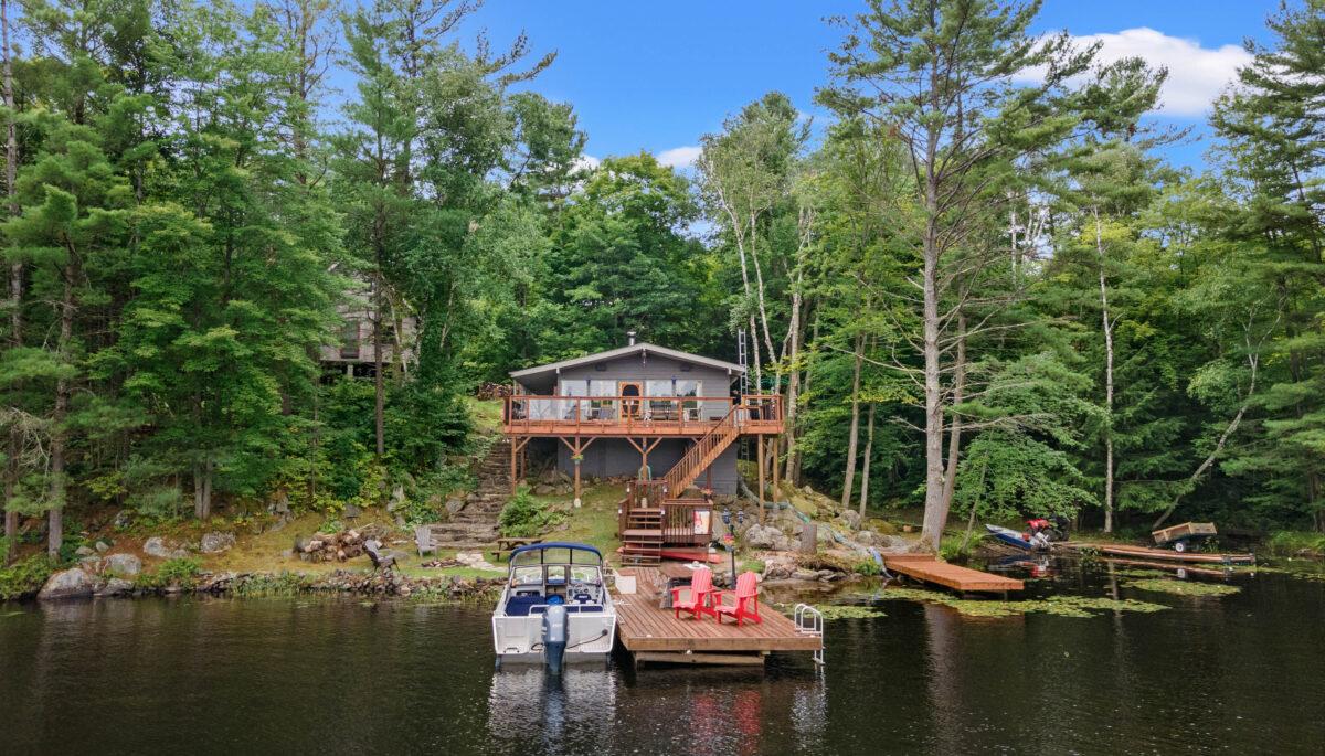 A grey cottage with a dock in front