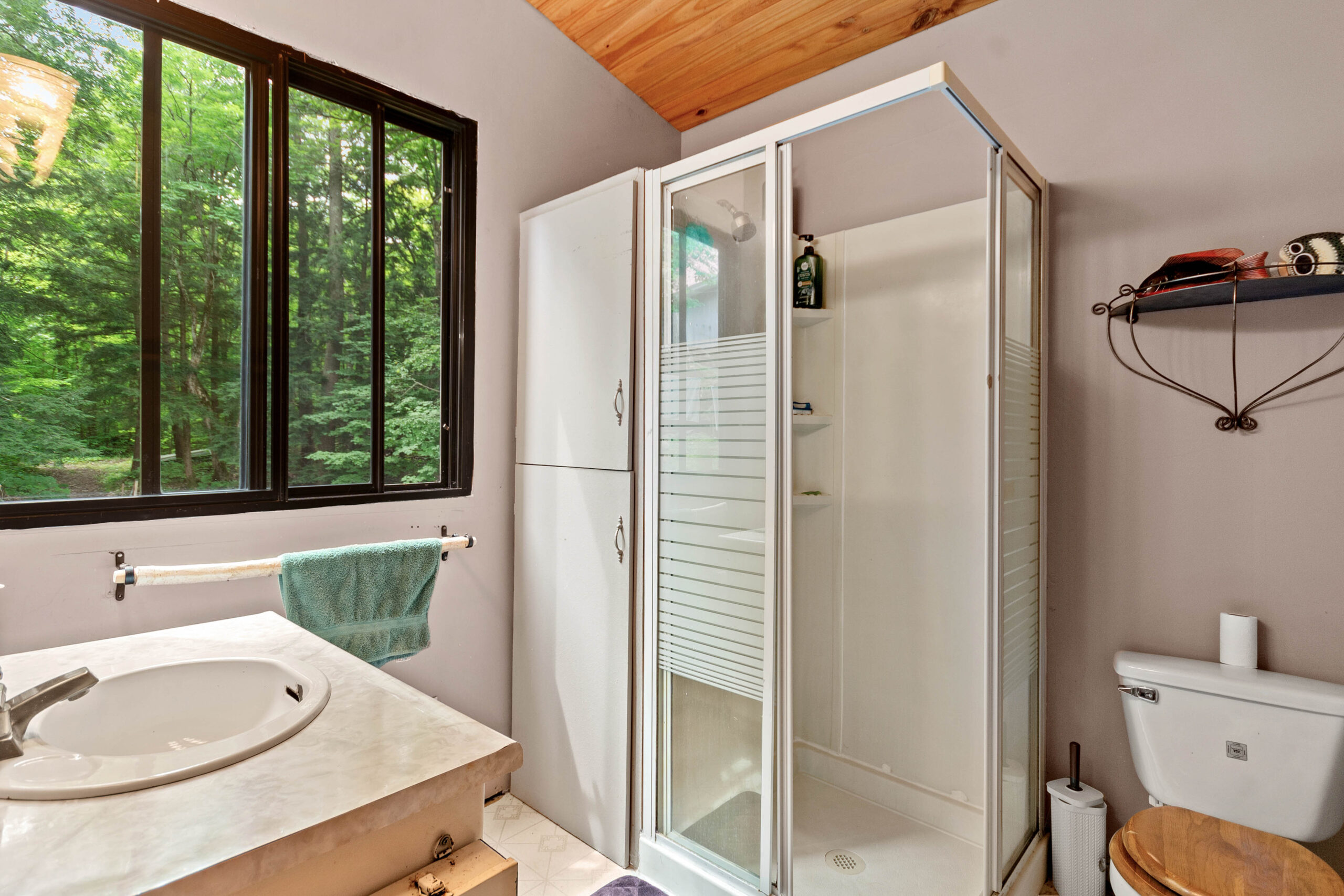A white walk-in shower in a white bathroom
