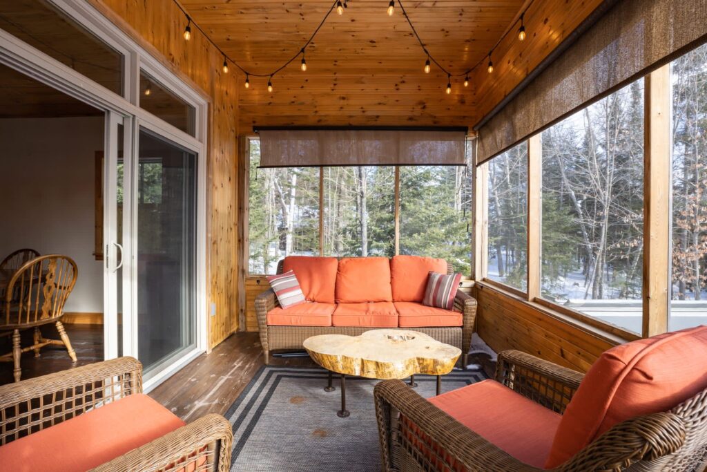 A bright sun room with peach-coloured wicker furniture facing each other
