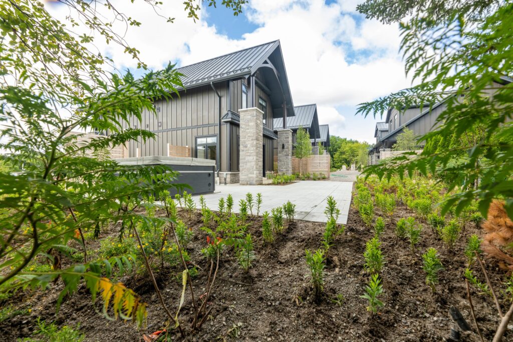 The side of the cottage with a stone patio and a closed hot tub