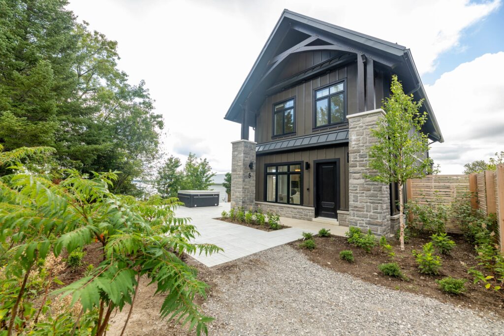 A two-story stone and grey-paneled cottage