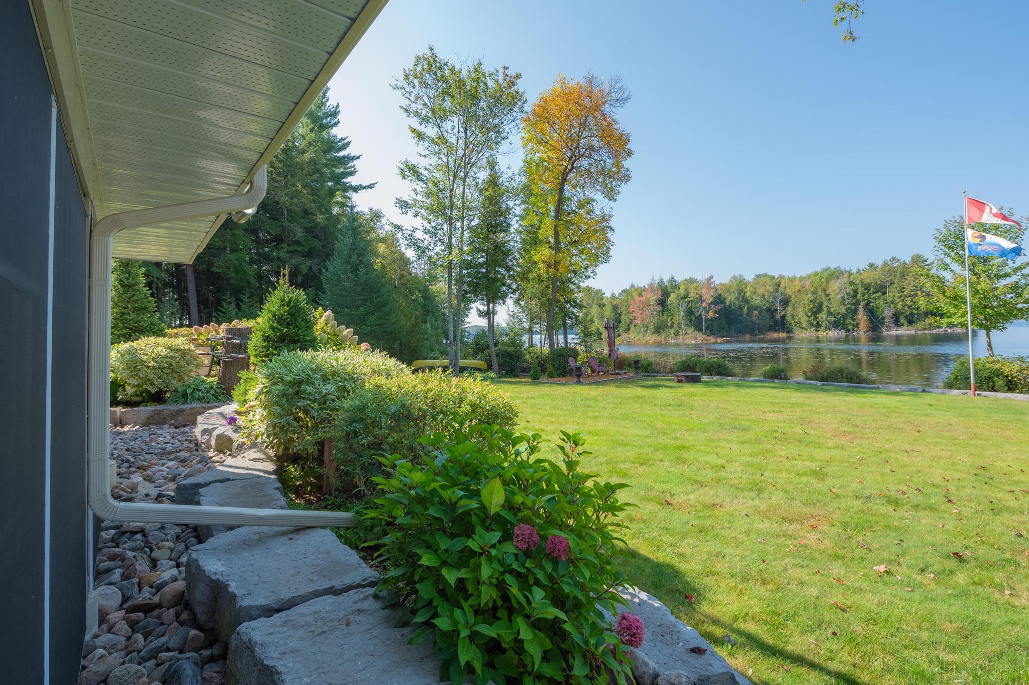 A wide-open green space with a patio area, perfect for outdoor relaxation by the lake.