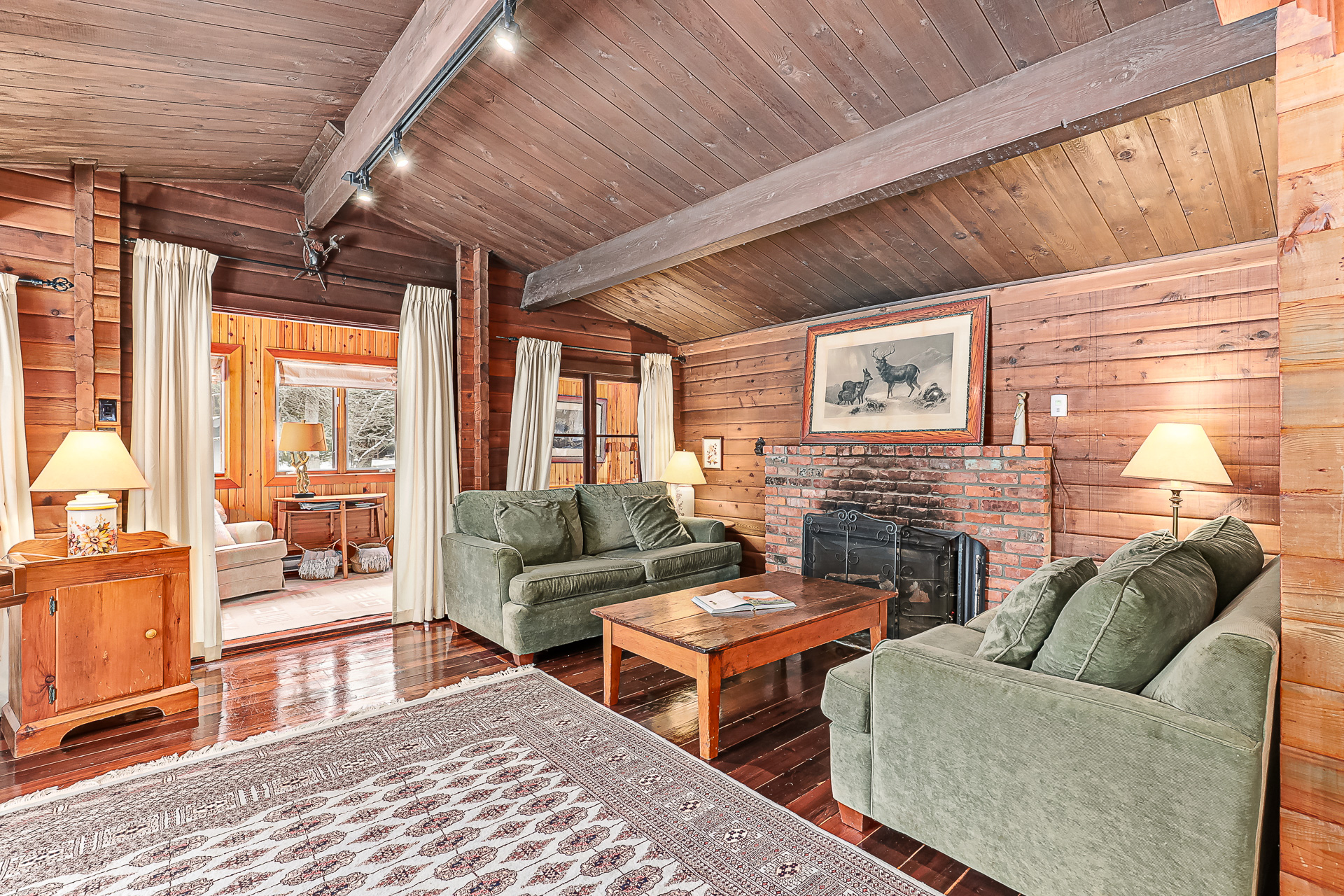 Two green loveseats face each other with a wood coffee table in between