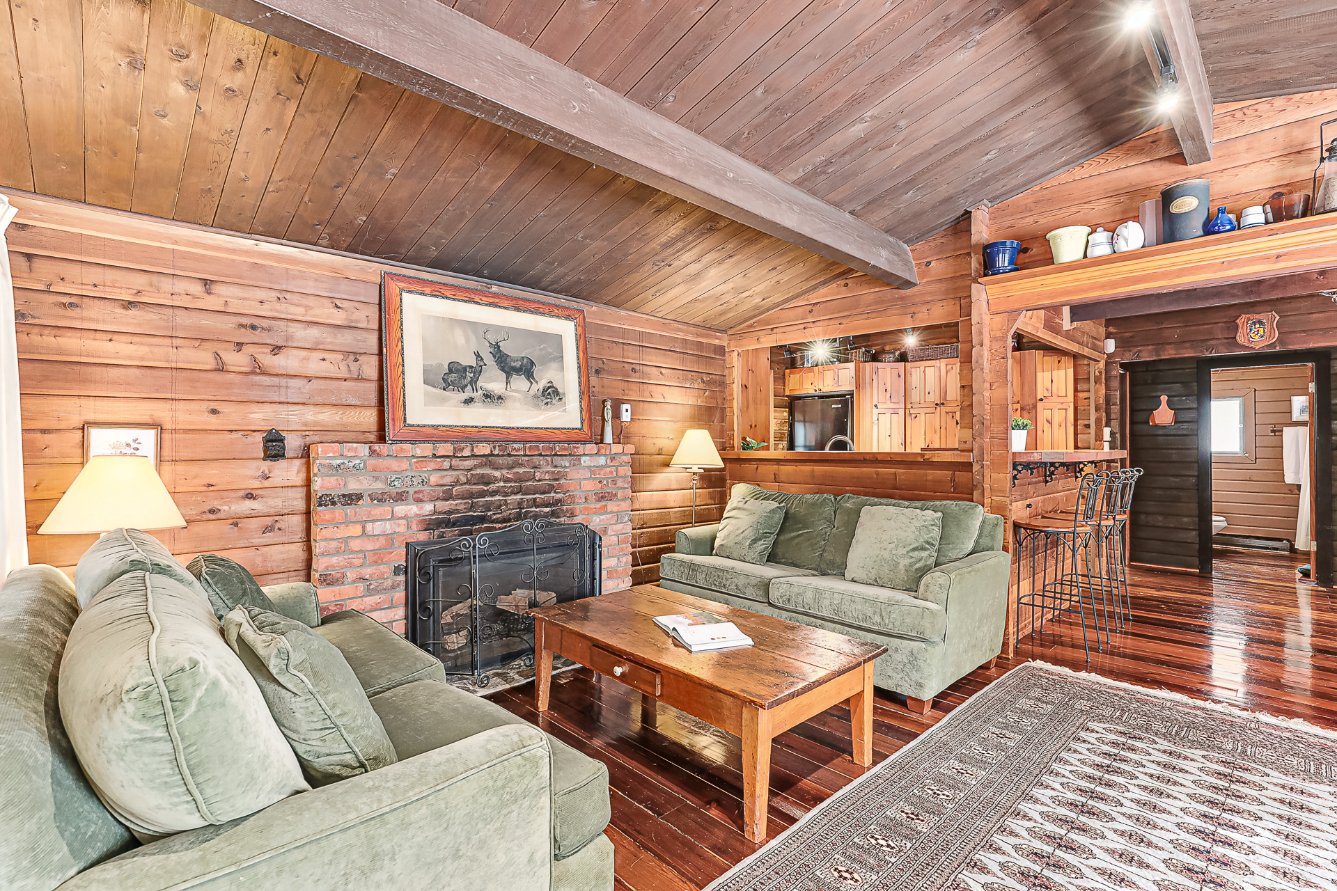 Two green loveseats face each other with a wood coffee table in between