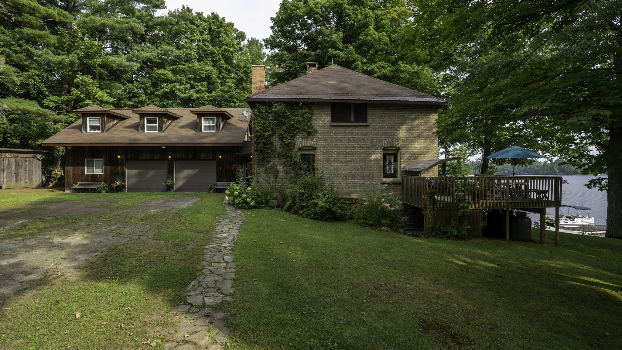Front exterior of a century farmhouse surrounded by trees at Lake Muskoka
