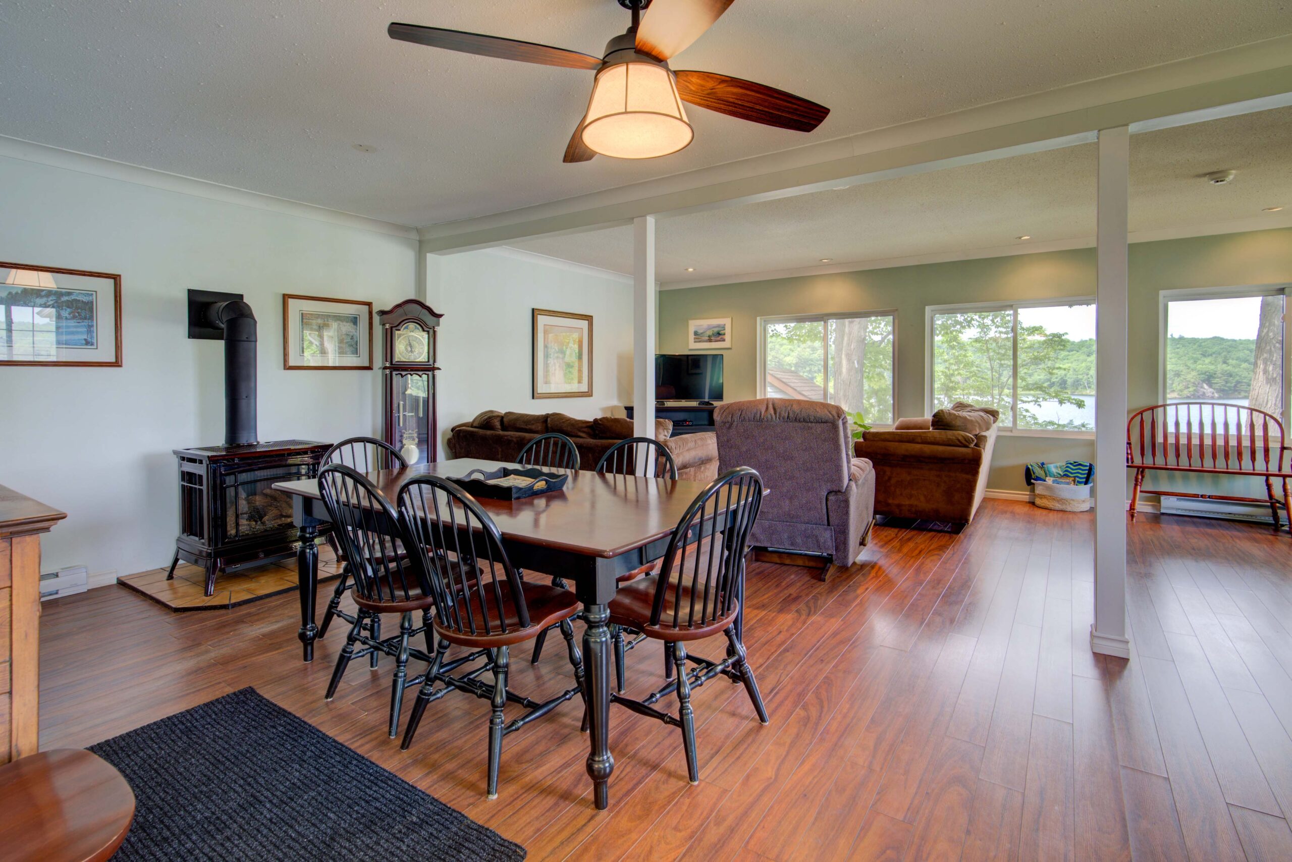 A wood dining table with black chairs in an open-concept living space