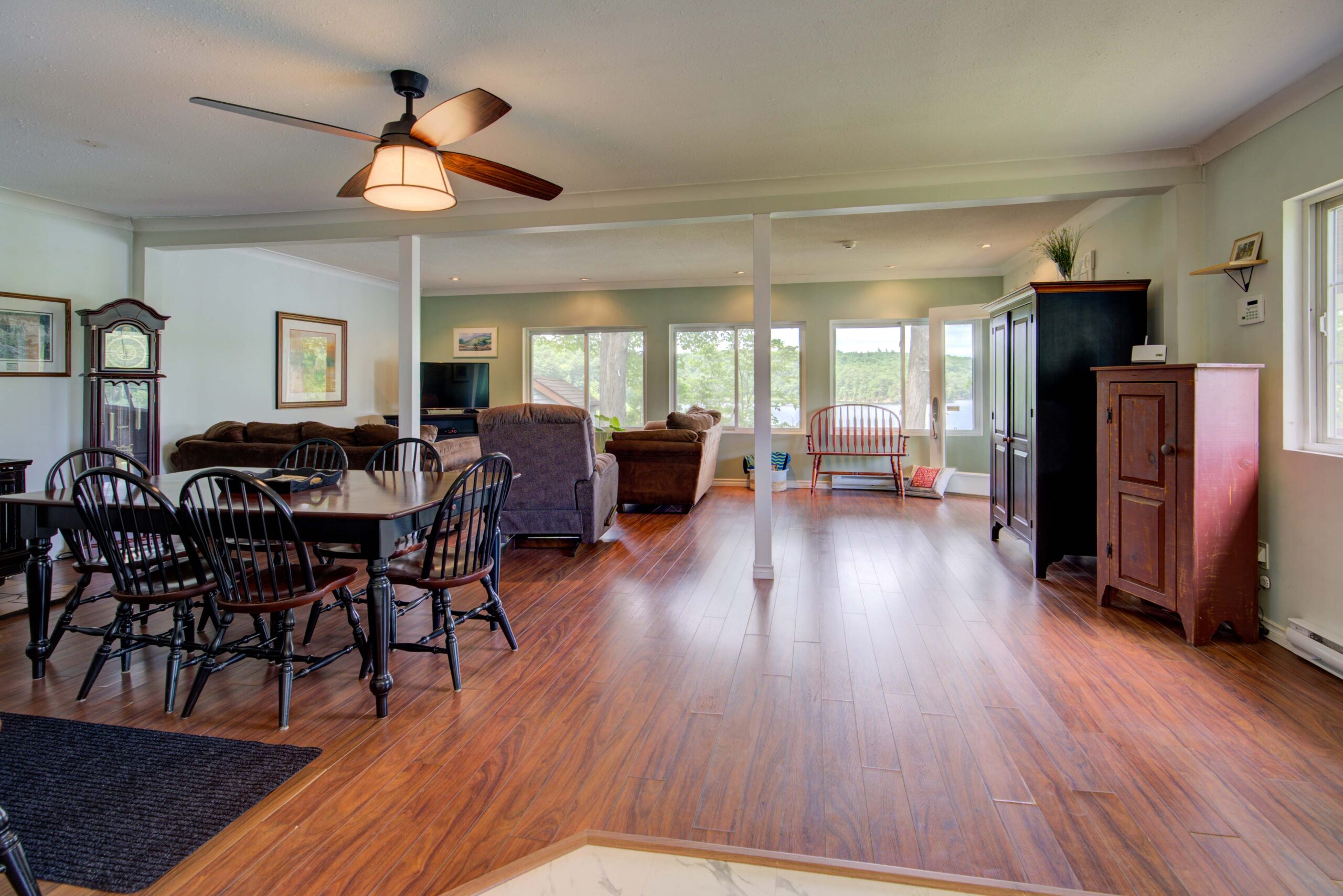A spacious dining and living area with red-brown floors